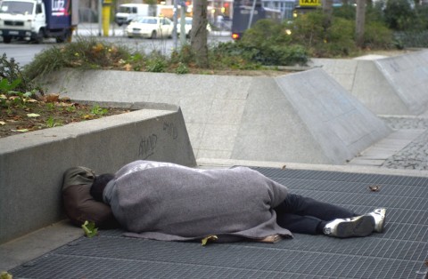 Ein Obdachloser übernachtet auf einem Abluftschacht der U-Bahn an der Bockenheimer Warte. Foto: Rolf Oeser
