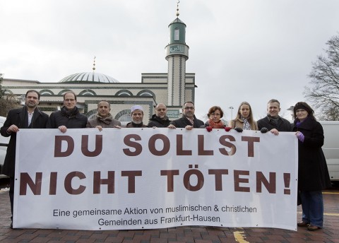 Die Beteiligten an dem Projekt zeigen das Banner vor der Abu Bakr Moschee. Foto: Rolf Oeser